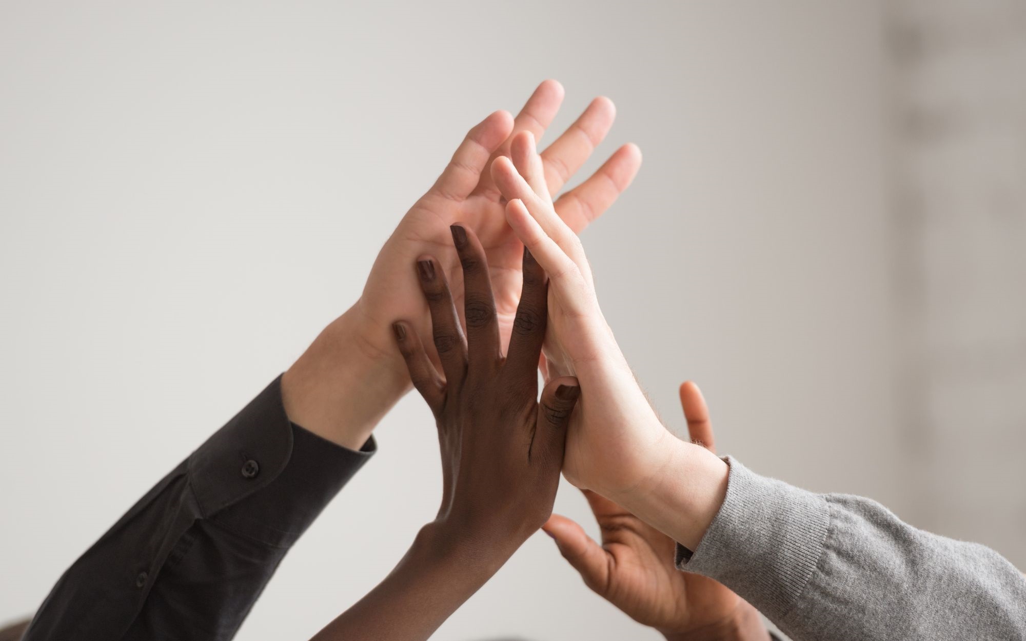 4 different hands coming together in solidarity