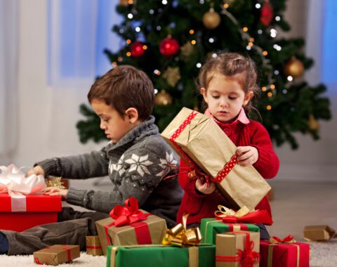 Two young children opening christmas presents