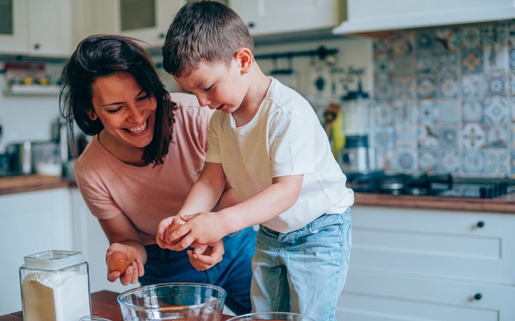 Young woman in a kitchen with her son baking