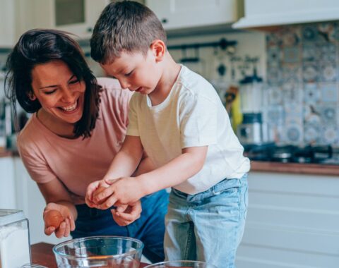 Young woman in a kitchen with her son baking