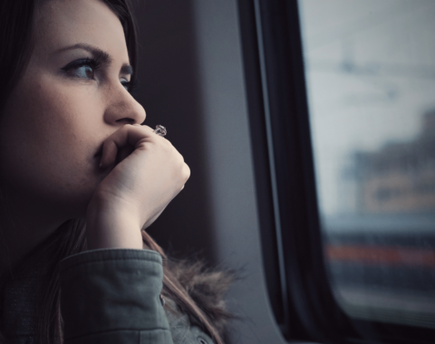 Young woman looking out a train window