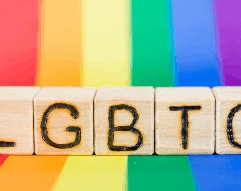 LGBTQ block with rainbow behind