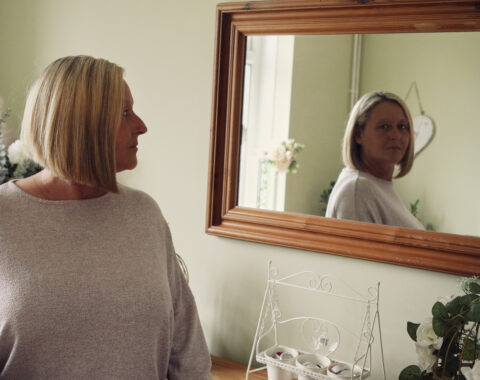 woman looking in mirror